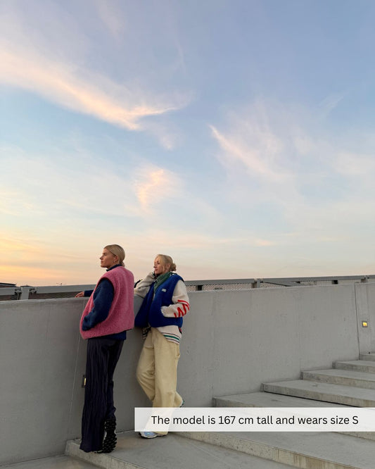 Woman wearing a merino wool vest outside, lightweight merino wool vest ideal for travel and changing weather