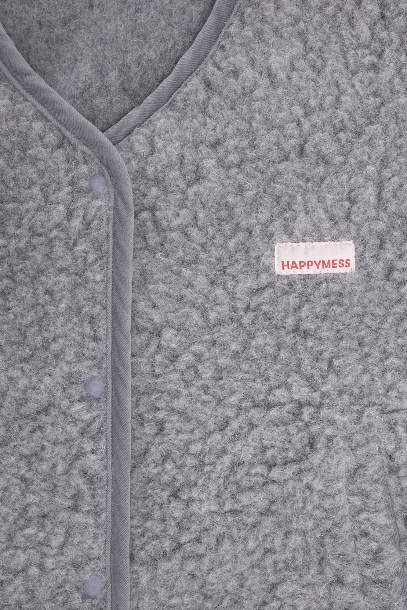 Close-up texture of grey merino wool vest fabric showing soft natural merino wool fibers