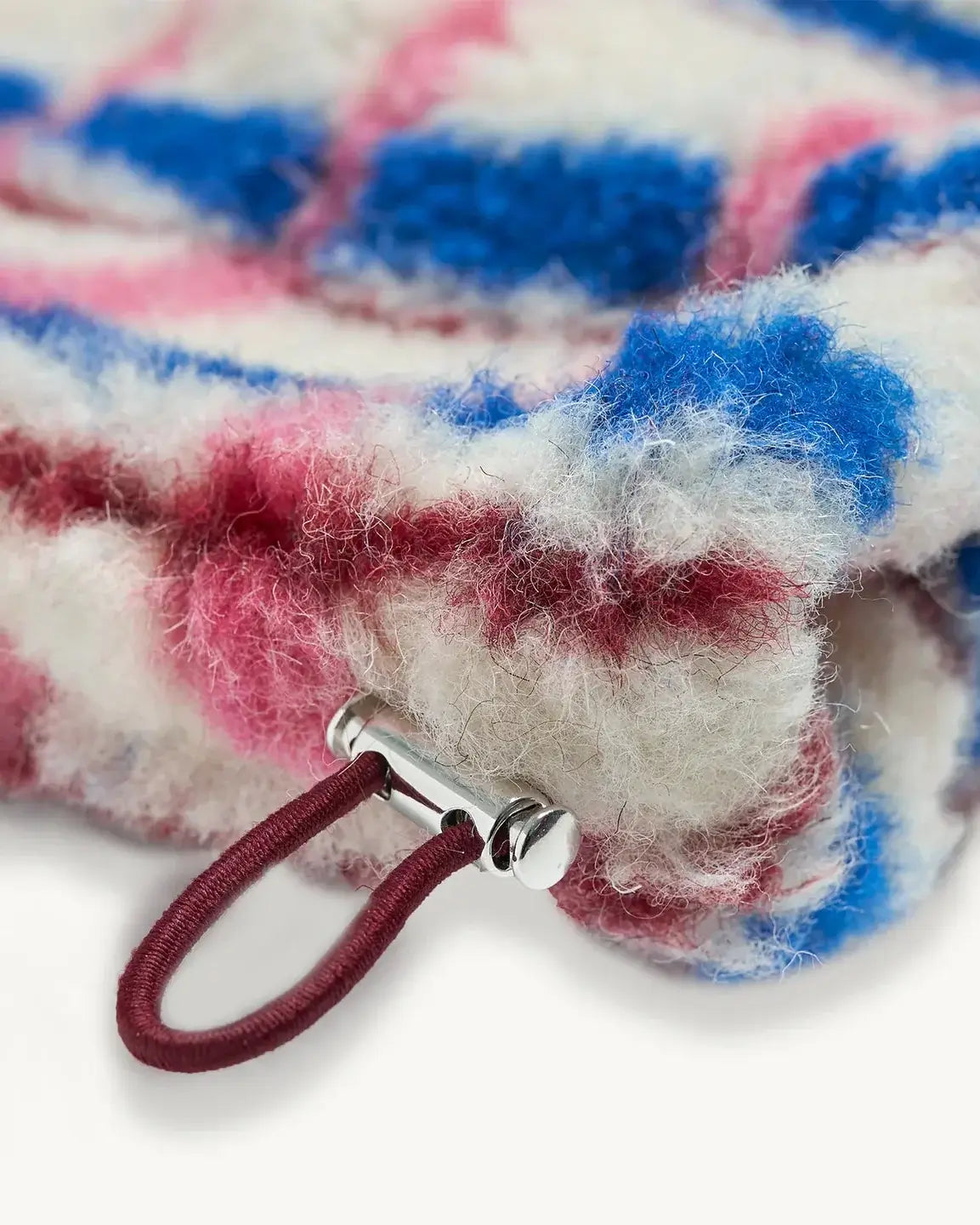 Close-up of the adjustable drawstring on the 100% merino wool jacket in pink and cobalt colors.