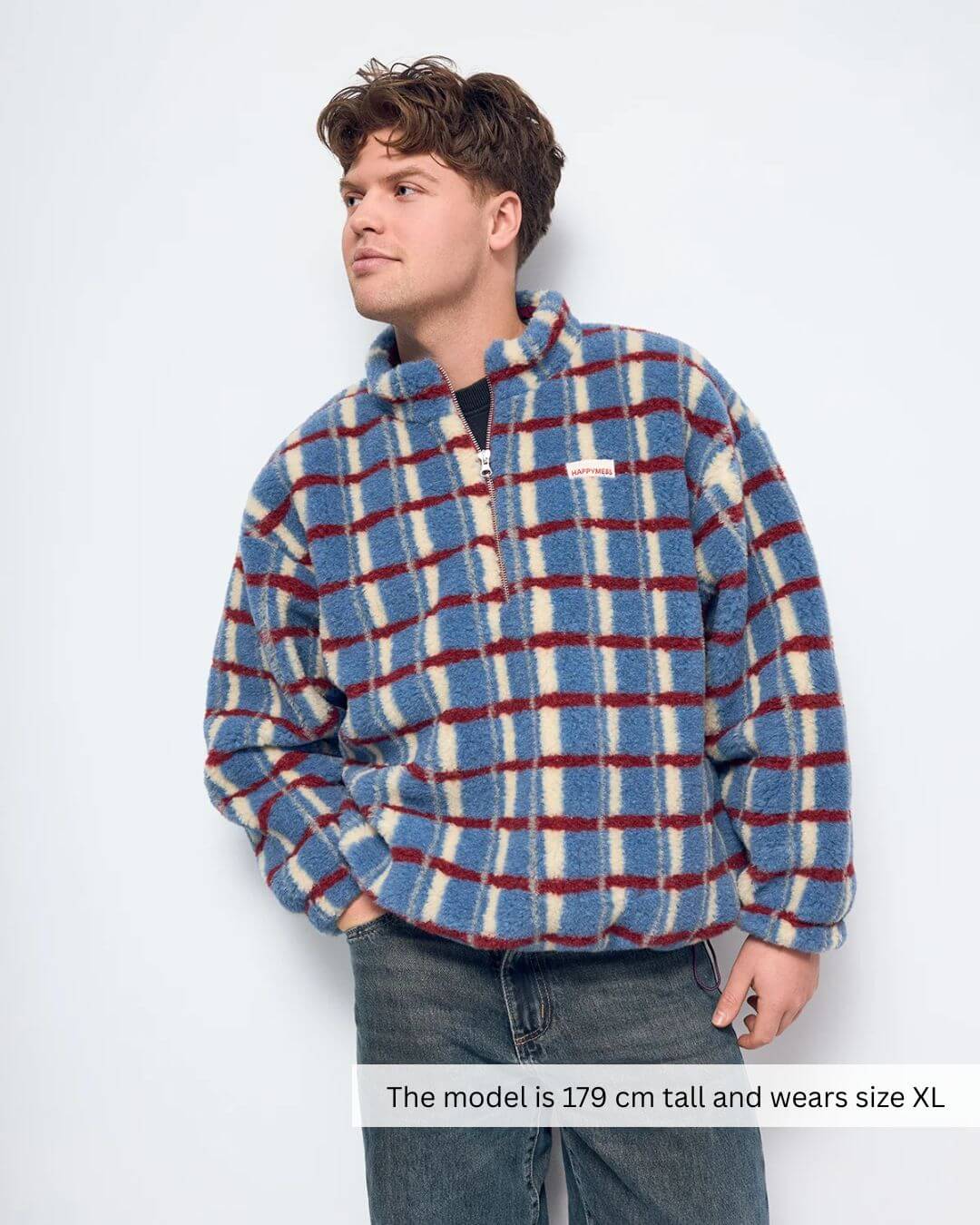 Model wearing a Merino Wool Fleece Jacket in Shadow Blue with a plaid design, featuring a zipper and stand-up collar.