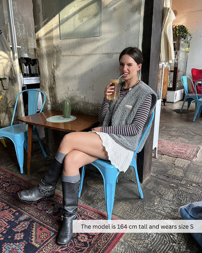 Woman wearing a merino wool vest in a city setting, stylish merino wool vest for everyday wear