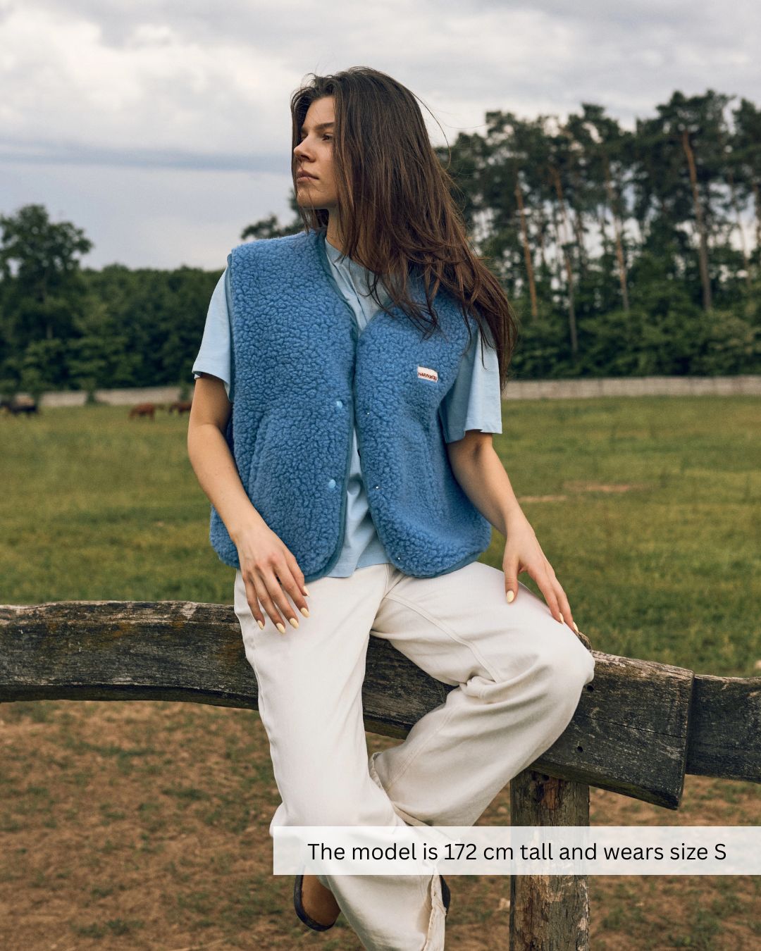 Woman wearing a blue merino wool vest outdoors, stylish merino wool vest for everyday wear