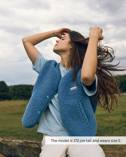 Woman wearing a blue merino wool vest in a relaxed outfit, soft merino wool vest for everyday comfort