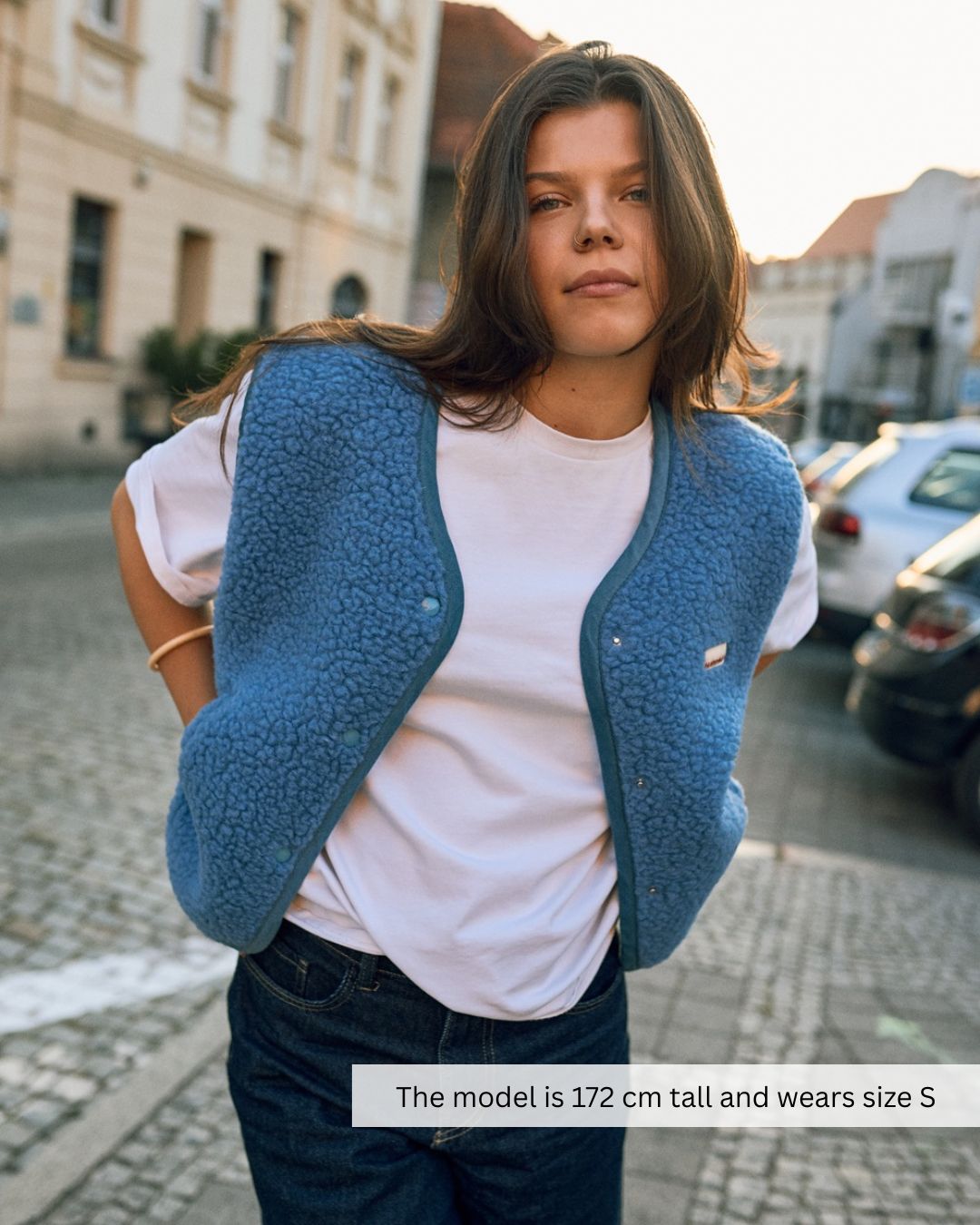 Woman walking in a blue merino wool vest, lightweight merino wool vest perfect for casual outfits